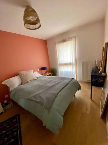 um quarto com uma cama grande e uma janela em Appartement lumineux et calme em Bordeaux
