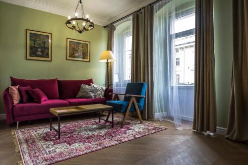 a living room with a purple couch and a table at Apartamenty Nowa Ruda in Nowa Ruda