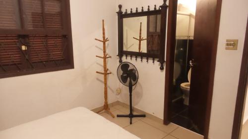 Pokój z łóżkiem, lustrem i zegarem w obiekcie Chacara Completa A 500mts da entrada do thermas e 2Km de aguas de sp w mieście São Pedro