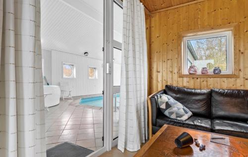 a living room with a leather couch and a table at Lovely Home In Ebeltoft With Swimming Pool in Ebeltoft