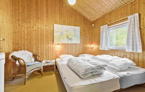 a bedroom with two beds and a chair and a window at Lovely Home In Ebeltoft With Swimming Pool in Ebeltoft