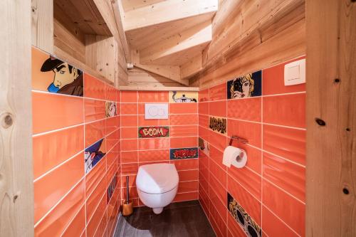 a bathroom with orange tiled walls and a toilet at Chalet le Ber Abbay in Abondance