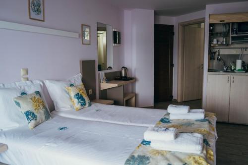 a bedroom with a large white bed with towels on it at Drenia Studios in Ammouliani