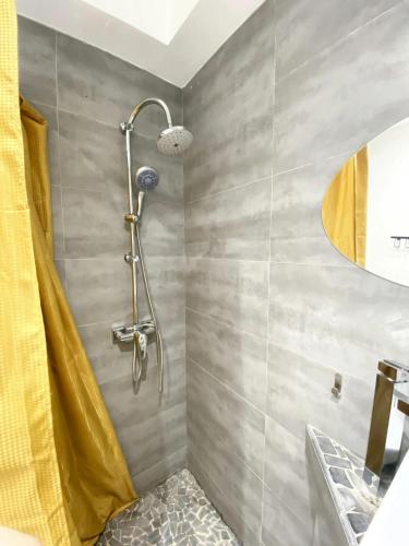 La salle de bains est pourvue d'une douche avec un rideau jaune. dans l'établissement Studio moderne à Cap d'Agde - 15 m² - Proche des plages, au Cap d'Agde