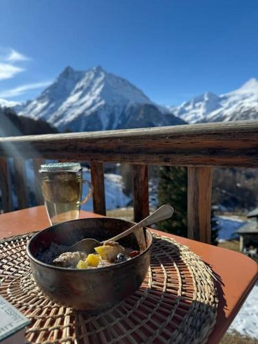 a bowl of food on a grill on a table with mountains at Chalet Alouette in Evolène