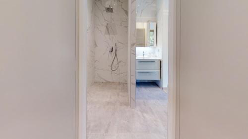 een badkamer met een douche en een marmeren muur bij Maison Olivier in Veigy-Foncenex