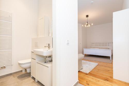 a white bathroom with a toilet and a sink at Cosy Apartment Berlin Neukölln in Berlin
