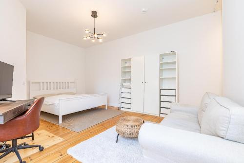 a white living room with a white couch and a desk at Cosy Apartment Berlin Neukölln in Berlin