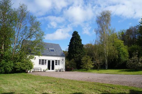 a white house with a gravel driveway at Burraton Cob in Exeter