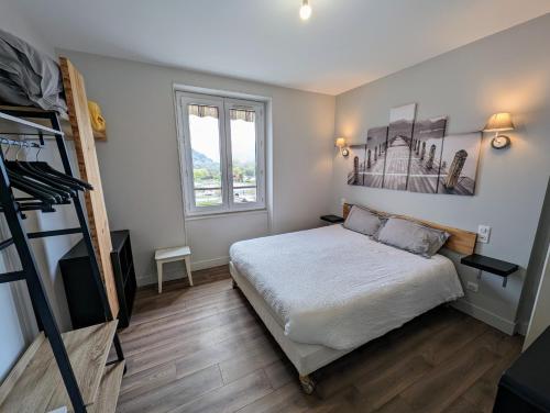 a small bedroom with a bed and a ladder at Logis Hôtel Le Beau Site in Chambon-sur-Lac