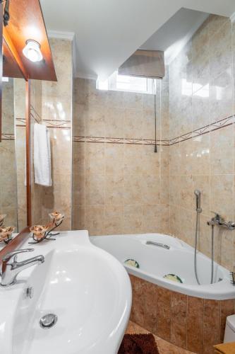 a bathroom with a bath tub and a white sink at Niki's House in Gournes