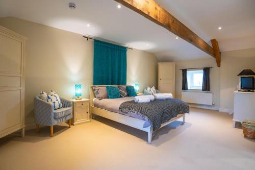 un dormitorio con una cama y una silla en The Outbuildings, en Newborough