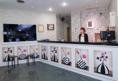 a woman standing at a counter withpainted vases at Hsinchu 101 Inn in Hsinchu City