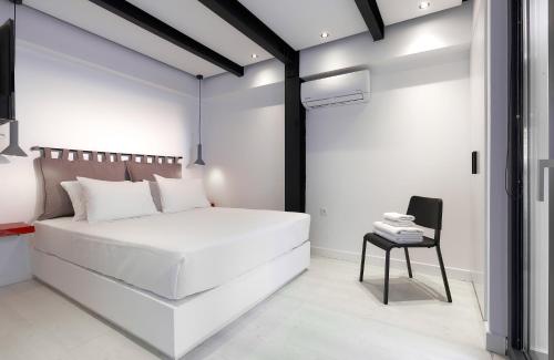a bedroom with a white bed and a table at MichELe Luxury apartments by Smaris Collection in Malia