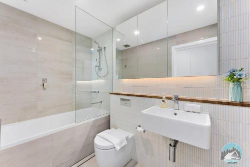 a bathroom with a toilet and a sink and a shower at Aircabin - Shell Cove - Waterview - 2 Bed Apt in Shellharbour