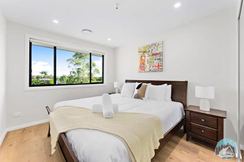Un dormitorio blanco con una cama grande y una ventana en Aircabin - Leppington - Lovely Comfy - 5 Bed House en Horningsea Park