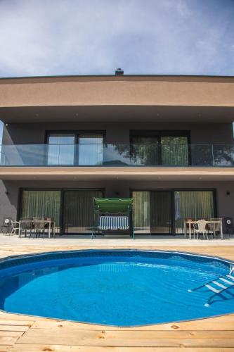 a swimming pool in front of a house at Lohovo Villa Bukva in Otoka