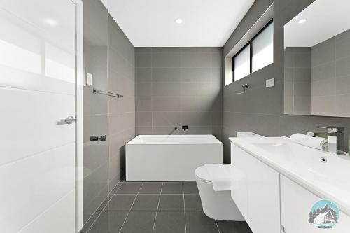 y baño con bañera, aseo y lavamanos. en Aircabin - Leppington - Lovely Comfy - 5 Bed House en Horningsea Park