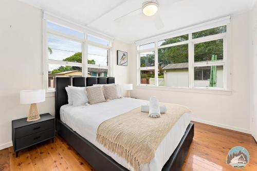 雪梨的住宿－Aircabin - North Ryde - Sydney - 4 Beds House，一间卧室设有一张大床和两个窗户。