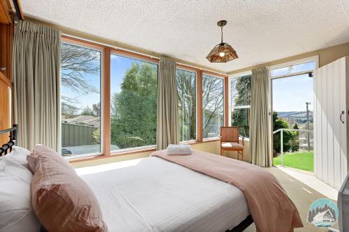 um quarto com uma cama e janelas grandes em Aircabin - Oberon - Great Location - Comfy Chalet em Oberon