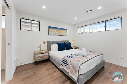 a bedroom with a large bed and two windows at Aircabin - Kingswood - Sydney - 3 Beds Townhouse in Kingswood