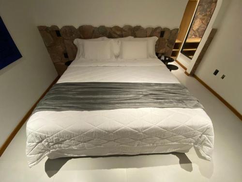 a bedroom with a large bed with white sheets at Villa Hortensia in Mucugê