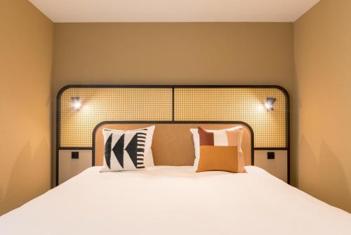 a bedroom with a large bed with white sheets and pillows at Cityden BoLo District in Amsterdam