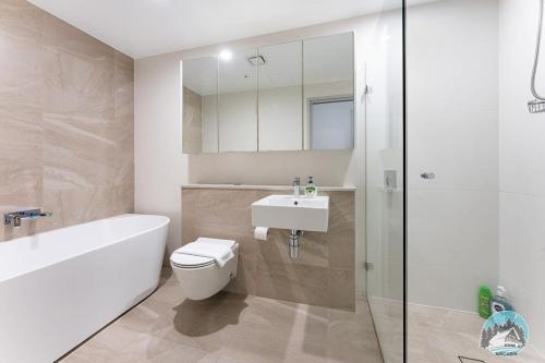 a bathroom with a toilet and a sink and a shower at Aircabin - Olympic Park - Cheerful - 3 Beds APT in Sydney