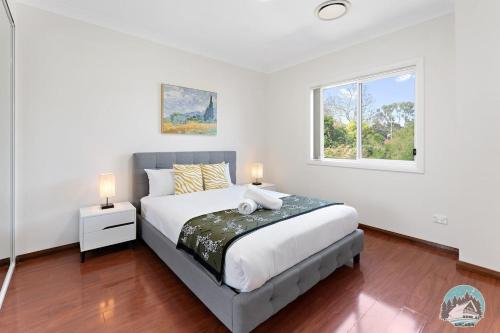 una camera con un grande letto e una finestra di Aircabin - Panania - Sydney - Cozy - 5 Beds House a Panania