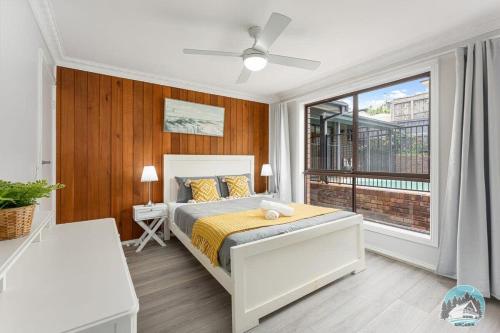 1 dormitorio con cama y ventana grande en Aircabin - Central Coast - 4 Beds House Bateau Bay, en Bateau Bay