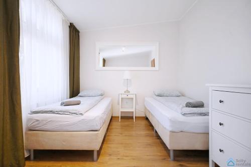 a bedroom with two beds and a mirror at Apartament Chopin in Sopot