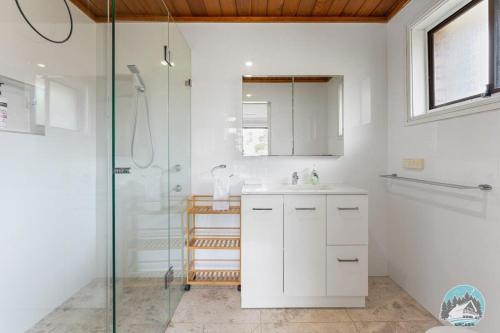 baño blanco con ducha y lavamanos en Aircabin - Central Coast - 4 Beds House Bateau Bay, en Bateau Bay