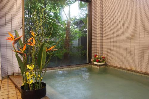 a swimming pool with a plant and a window at Hanagoyomi in Nanao