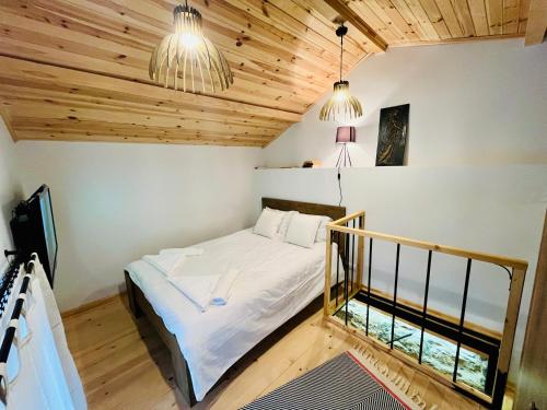 a bedroom with a bed in a room with wooden ceilings at Balloon Boutique House, City Centre in Plovdiv