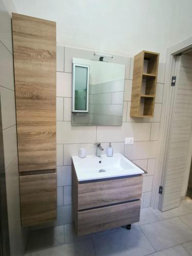 een badkamer met een wastafel en een spiegel bij Da nonna Concetta in Donnalucata