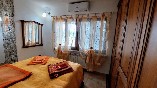 1 dormitorio con 1 cama y una ventana con cortinas en Vista Mare en Boissano