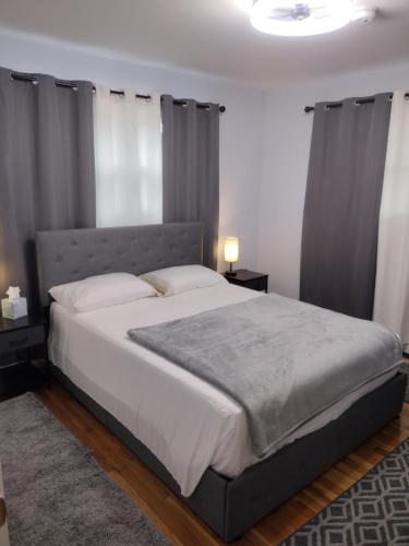 een slaapkamer met een groot bed met grijze gordijnen bij Spare Room Lodge at Flannagan Dam in Haysi