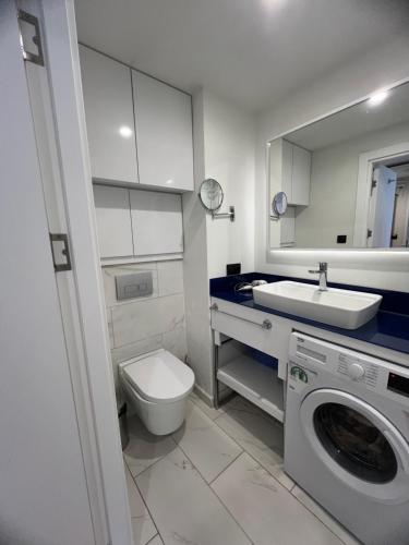 Orbi City Hotel في باتومي: حمام مع مرحاض ومغسلة وغسالة