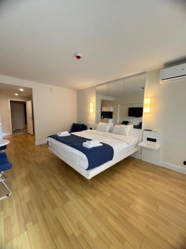 1 dormitorio con 1 cama grande y espejo grande en Orbi City Hotel en Batumi