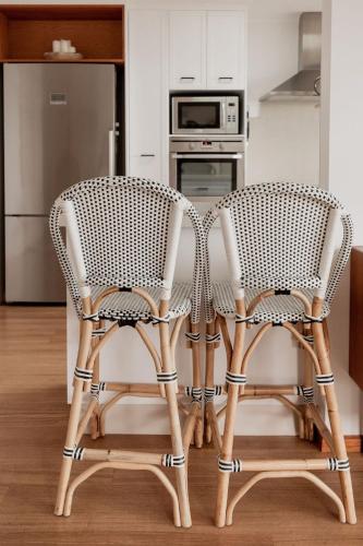 two chairs sitting next to a table in a kitchen at Seagrass Coastal Retreat with direct beach access in Lewisham