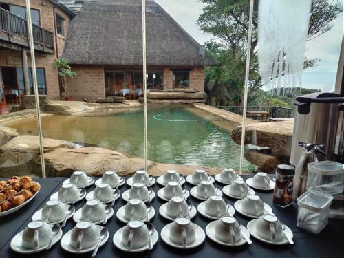 a bunch of tea cups and saucers on a table at Sugar Beach Resort in Elysium
