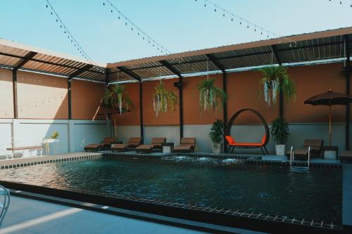 a swimming pool with chairs and an umbrella at Peppery Hills in Chiang Mai