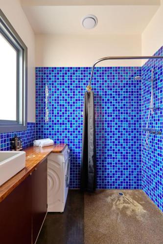 霍巴特'Elizabeth House=' in prime Hobart CBD location的蓝色瓷砖浴室设有水槽和淋浴