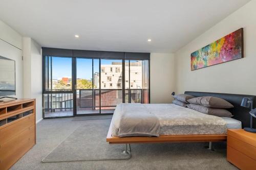 a bedroom with a bed and a large window at Inner-city 2 bedroom apartment - perfectly located in Hobart