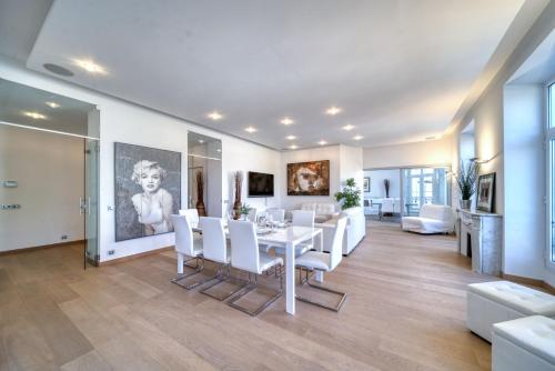 une salle à manger avec une table et des chaises blanches dans l'établissement Appartement Francis F. Copolla, à Cannes