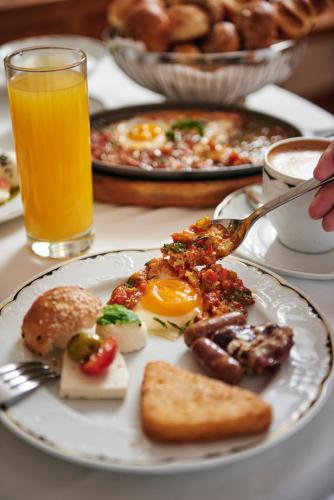 een bord ontbijtproducten met eieren, worst en toast bij InterContinental Al Jubail Resort in Al Jubail