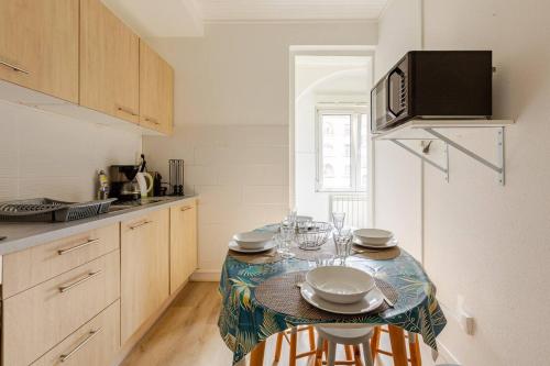 a kitchen with a table with chairs and a microwave at MAMRAY in Colmar