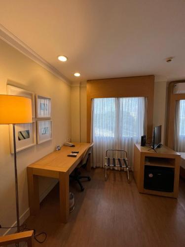 a room with a desk with a computer and a chair at Flat Hotel Aeroporto Congonhas UH1109 in São Paulo