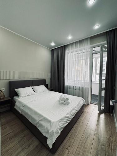 een slaapkamer met een bed met twee glazen erop bij 2-х комнатные апартаменты в ЖК GreenLine.Asyl Mura in Taldykolʼ