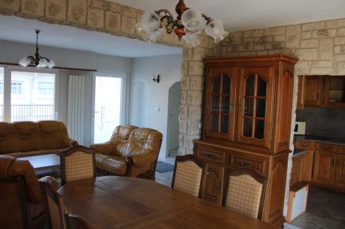 a living room with a dining table and a cabinet at Le gite de la Forêt in Herbsheim
